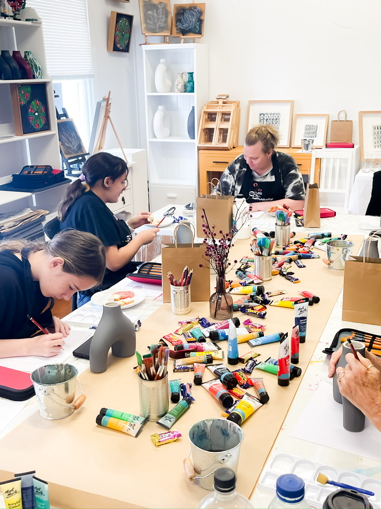 A facilitated workshop in progress at Studio on Brunswick: participants gathered at the long tables in warm natural light